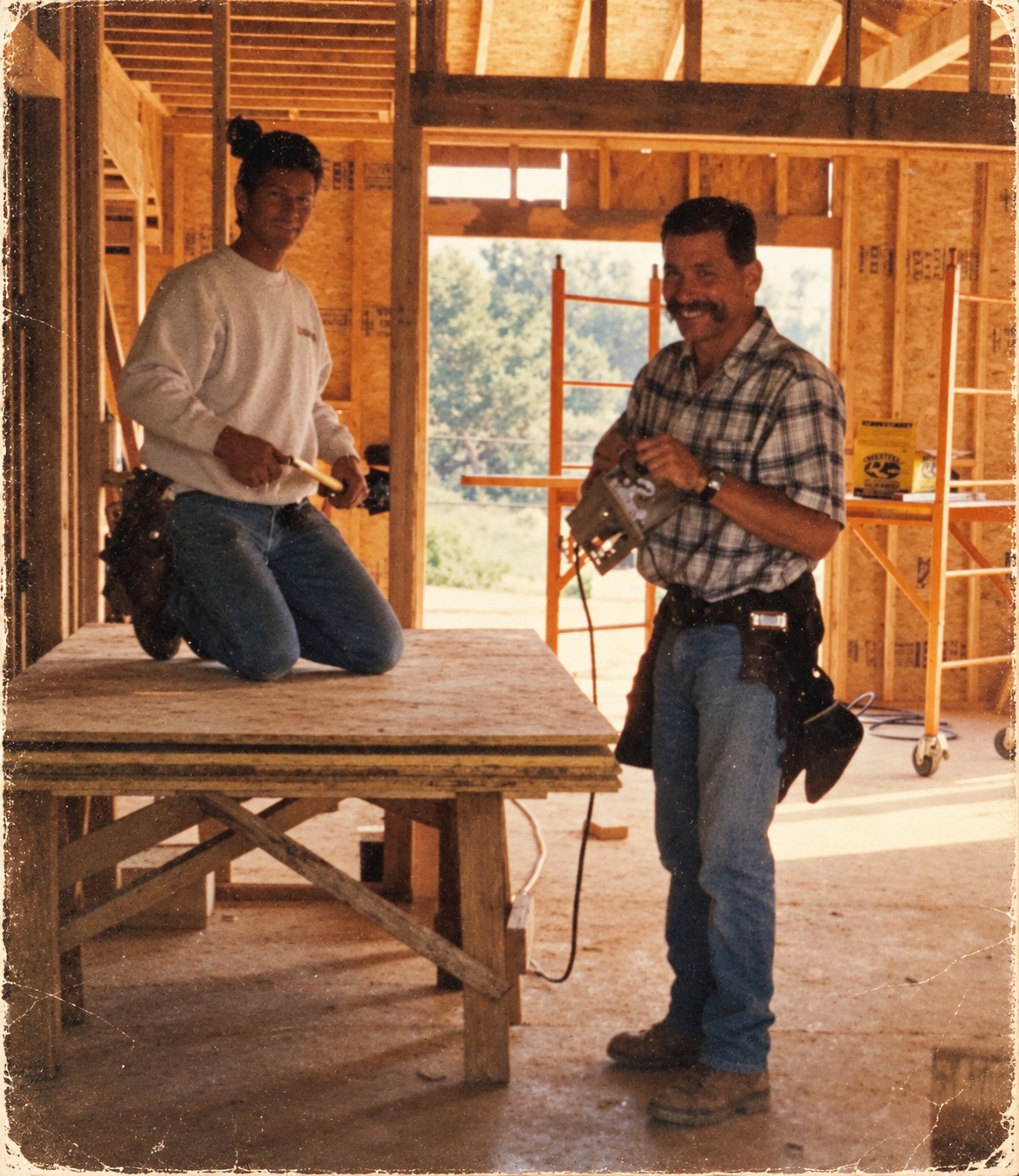 Two people at a timber-framed construction site, from the Gravatt family archive